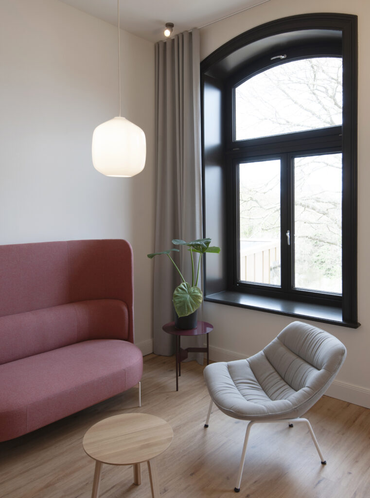 Lounge mit rotem Sofa und Pendelleuchte