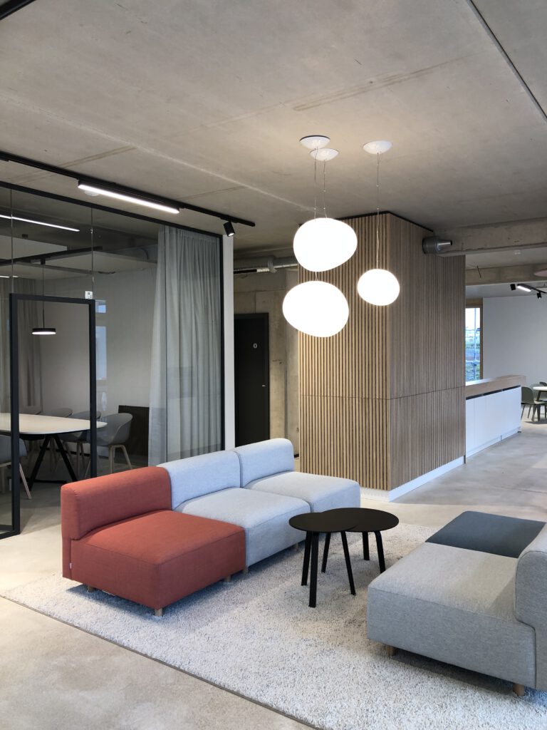 Lounge mit Pendelleuchten vor Meetingraum